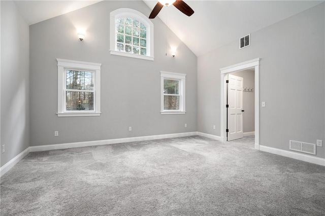 carpeted empty room featuring ceiling fan, plenty of natural light, and high vaulted ceiling