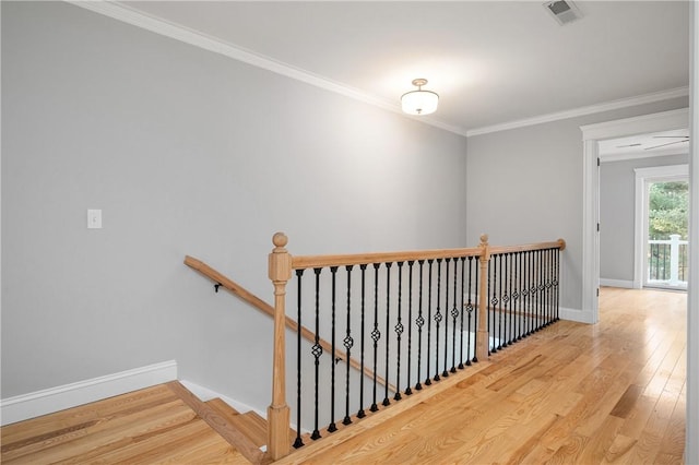 stairway featuring hardwood / wood-style floors and ornamental molding