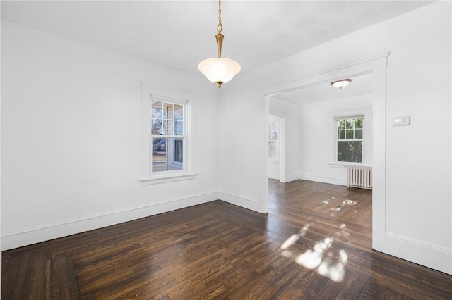 spare room with radiator and dark hardwood / wood-style flooring