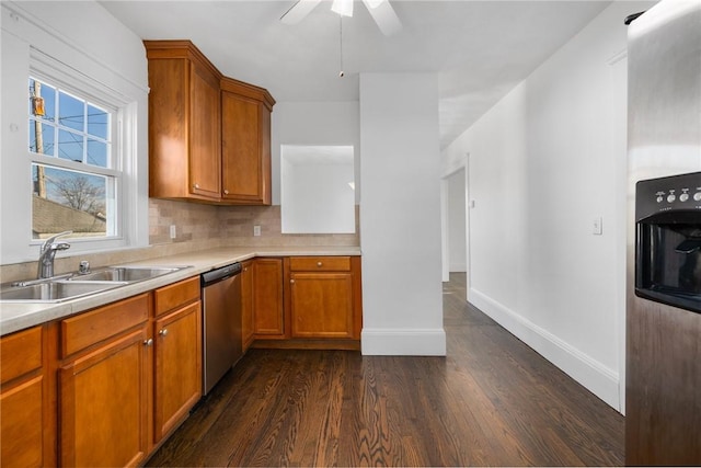 kitchen with dishwasher, dark wood-type flooring, sink, ceiling fan, and decorative backsplash