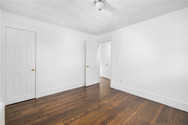 unfurnished room with dark hardwood / wood-style flooring