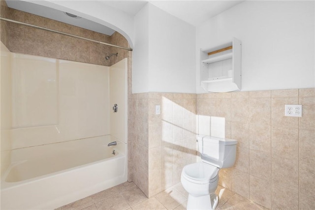 bathroom featuring tile patterned floors, toilet, shower / bath combination, and tile walls