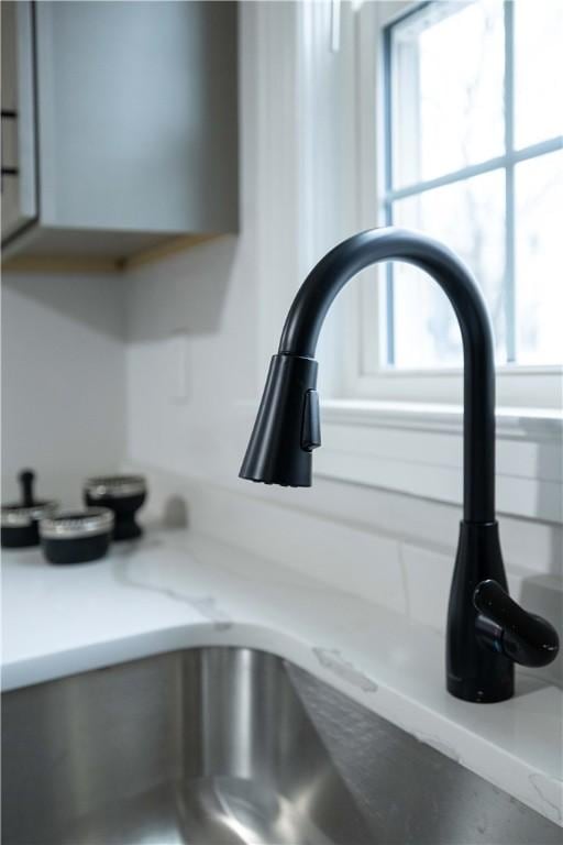 details with light stone countertops and sink