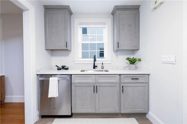 kitchen featuring gray cabinetry, dishwasher, light hardwood / wood-style flooring, and sink