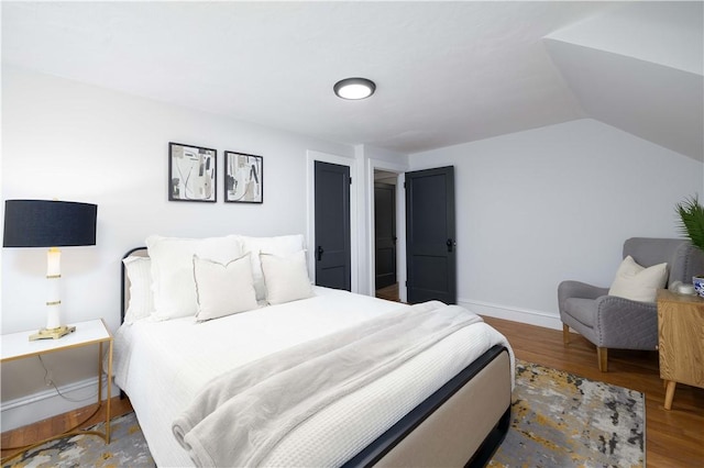 bedroom featuring wood-type flooring and vaulted ceiling