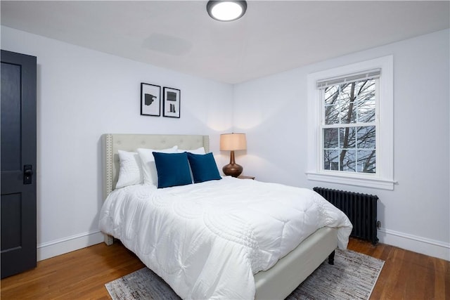 bedroom featuring radiator heating unit and hardwood / wood-style floors