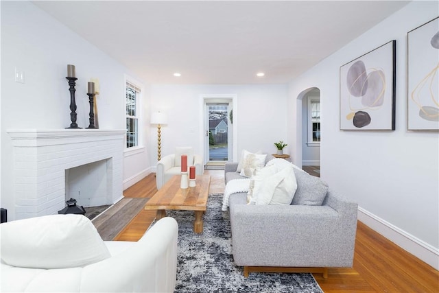 living room with light wood-type flooring and a brick fireplace