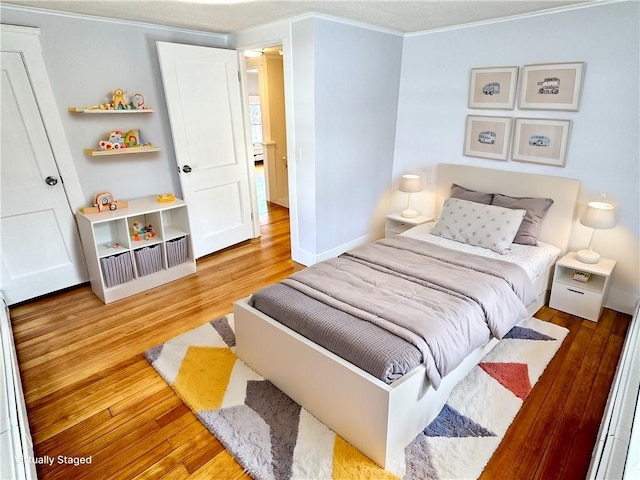 bedroom featuring ornamental molding and light hardwood / wood-style flooring