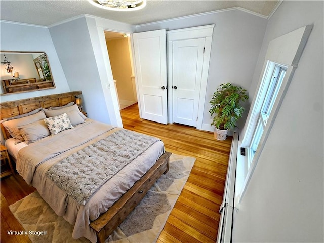 bedroom with crown molding and light hardwood / wood-style floors