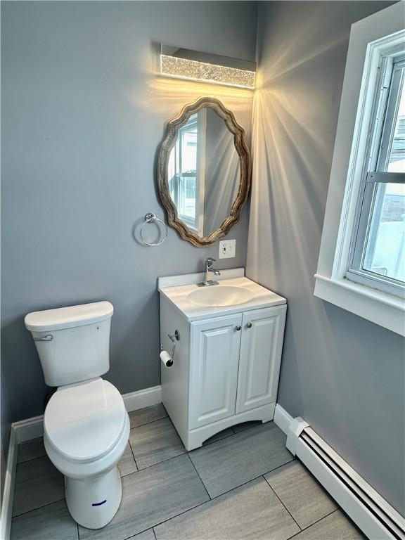 bathroom with vanity, toilet, and baseboard heating