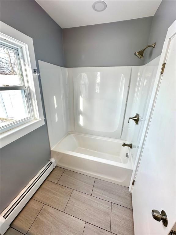 bathroom with a baseboard radiator and  shower combination