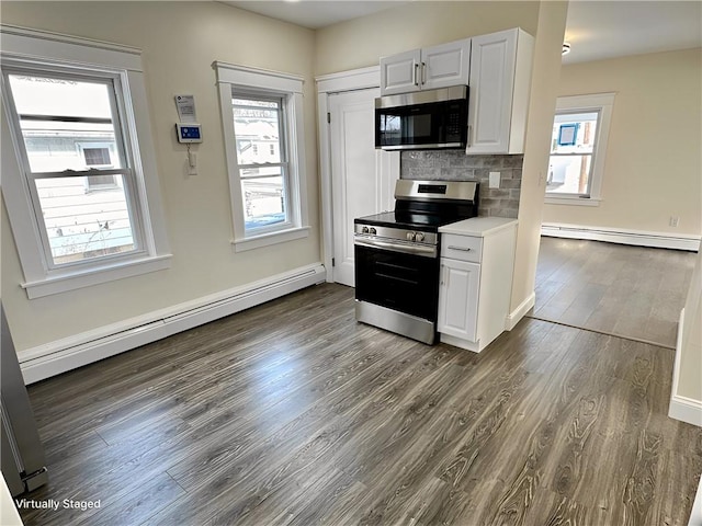 kitchen with backsplash, white cabinetry, baseboard heating, and stainless steel appliances