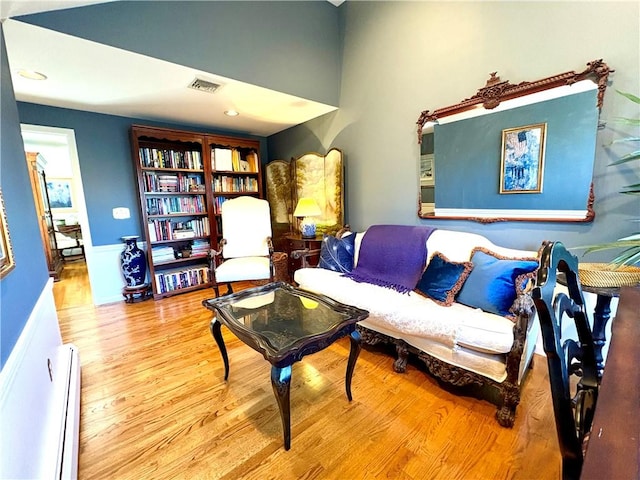 living area featuring baseboard heating and light hardwood / wood-style flooring