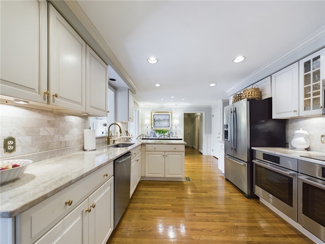 kitchen featuring decorative backsplash, appliances with stainless steel finishes, and white cabinetry