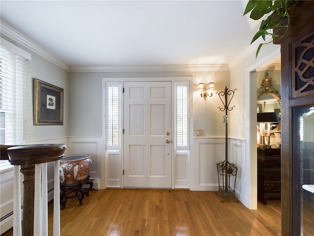 entrance foyer with light hardwood / wood-style floors, ornamental molding, and a baseboard radiator