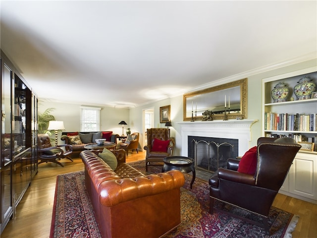 living room with hardwood / wood-style floors, built in features, and ornamental molding