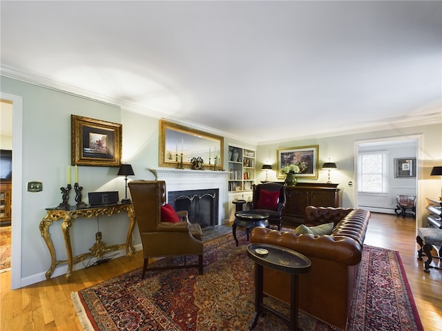 living room featuring built in shelves, light hardwood / wood-style floors, and ornamental molding