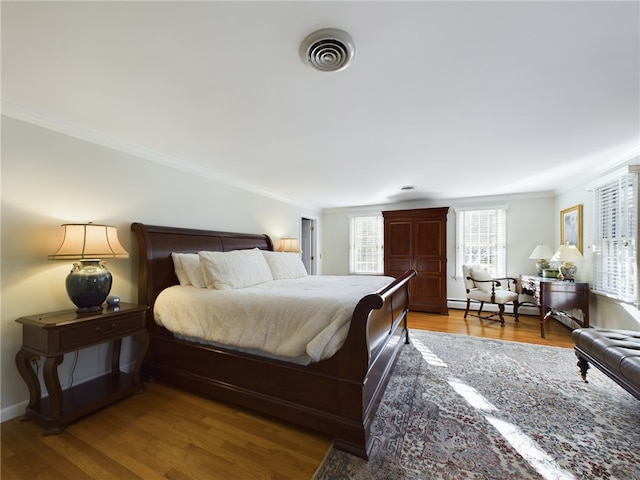 bedroom featuring hardwood / wood-style floors and crown molding