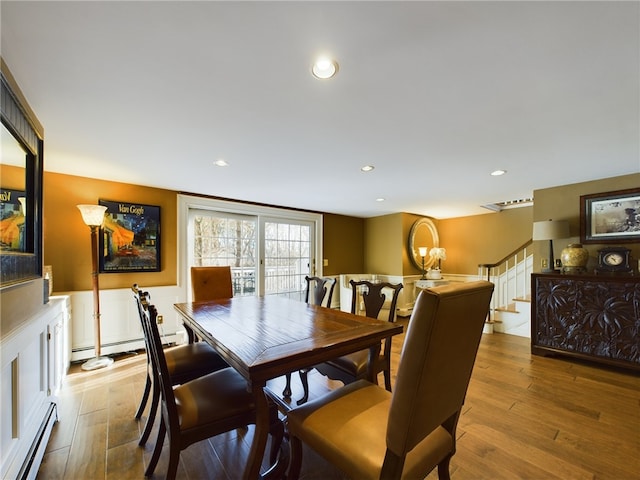 dining area with light wood-type flooring and a baseboard heating unit