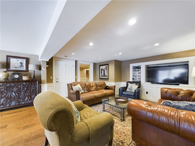 living room featuring built in features and light hardwood / wood-style floors