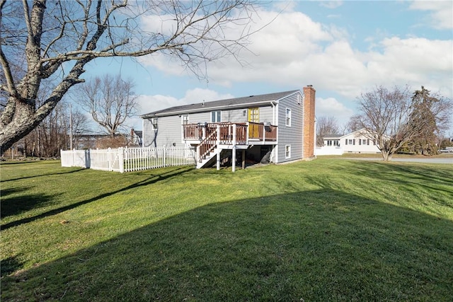 rear view of house with a yard and a wooden deck