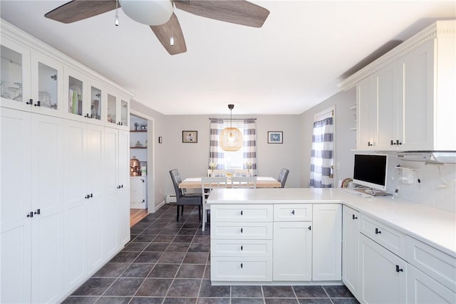 kitchen featuring white cabinets, decorative light fixtures, kitchen peninsula, and ceiling fan