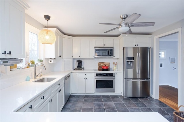 kitchen featuring white cabinets, decorative light fixtures, sink, and stainless steel appliances