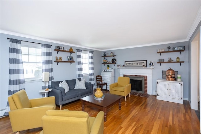 living room featuring hardwood / wood-style floors, ornamental molding, and a fireplace