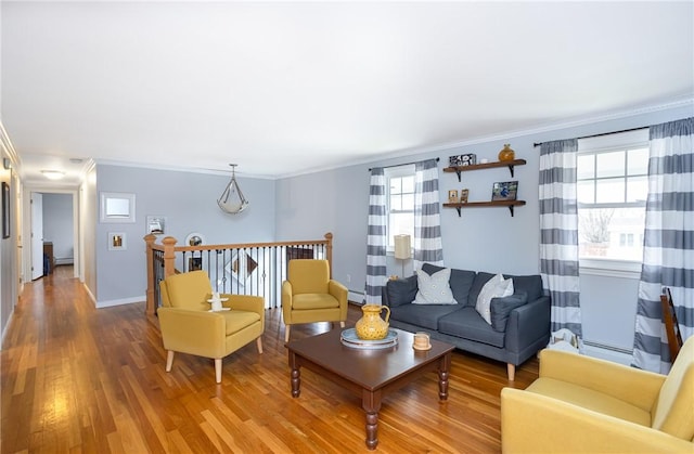 living room featuring baseboard heating, crown molding, and wood-type flooring