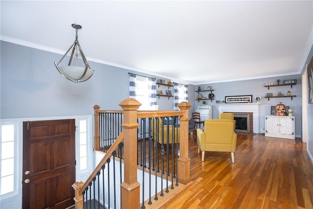 interior space with hardwood / wood-style flooring, ornamental molding, and a fireplace