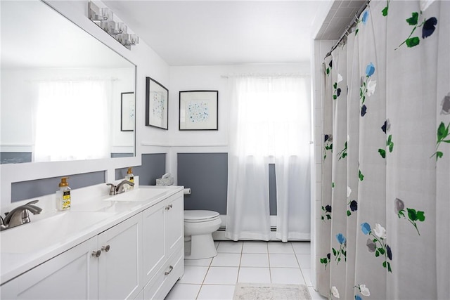 bathroom featuring tile patterned floors, vanity, baseboard heating, toilet, and curtained shower