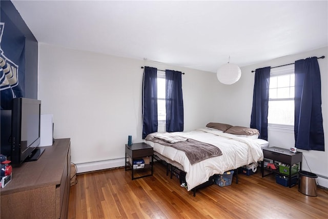 bedroom featuring hardwood / wood-style floors and baseboard heating