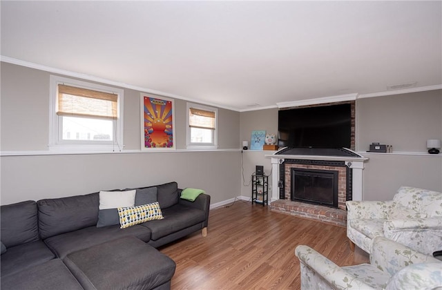 living room featuring a fireplace, wood-type flooring, and crown molding