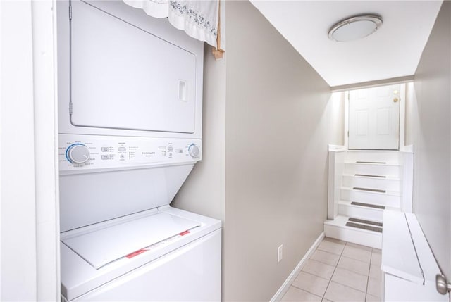 washroom featuring stacked washer / drying machine and light tile patterned flooring