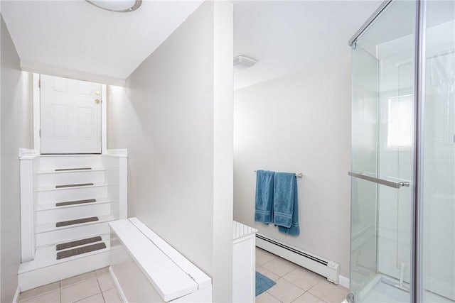 bathroom with tile patterned floors, a shower with door, and a baseboard heating unit