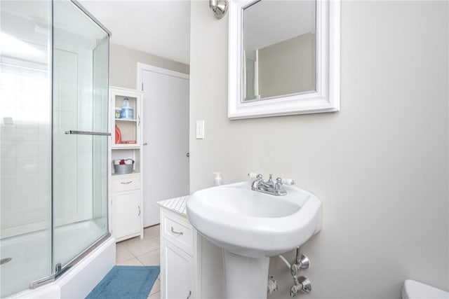 bathroom featuring tile patterned flooring and a shower with shower door