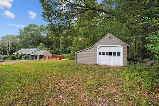 view of yard featuring a garage and an outbuilding