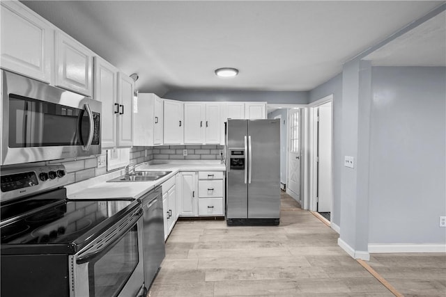 kitchen featuring white cabinets, backsplash, stainless steel appliances, and light hardwood / wood-style floors