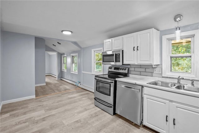 kitchen with stainless steel appliances, vaulted ceiling, sink, decorative light fixtures, and white cabinets