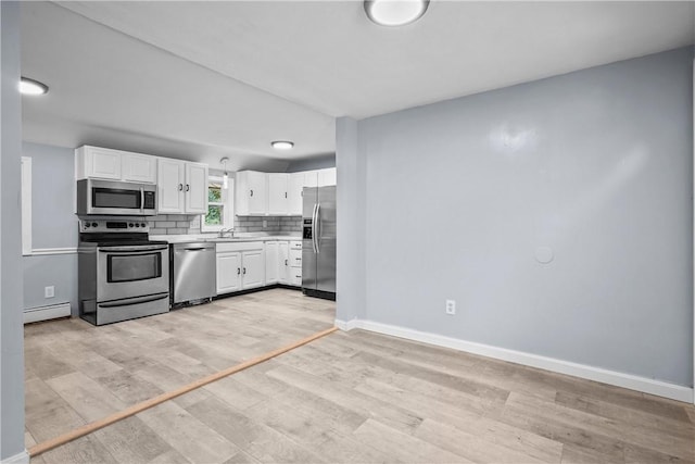 kitchen featuring white cabinets, light hardwood / wood-style floors, appliances with stainless steel finishes, and a baseboard radiator