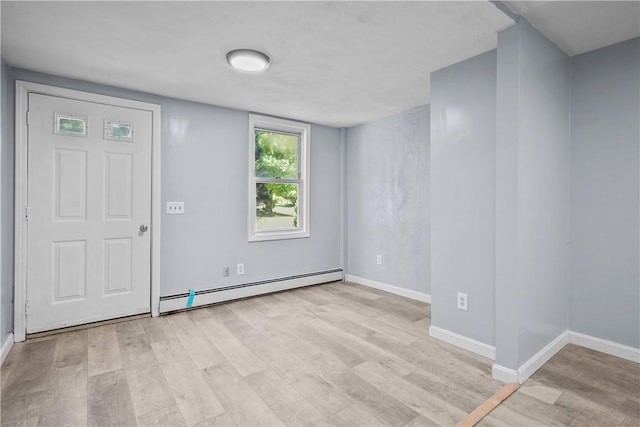 foyer entrance featuring a baseboard radiator and light hardwood / wood-style floors