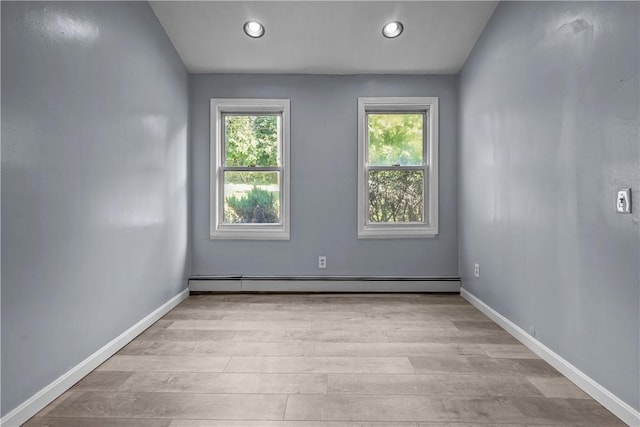 unfurnished room featuring light hardwood / wood-style flooring and a baseboard radiator