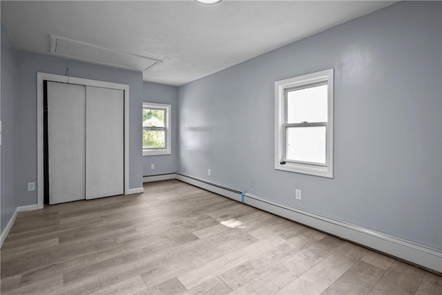 unfurnished bedroom featuring a baseboard radiator and light hardwood / wood-style floors