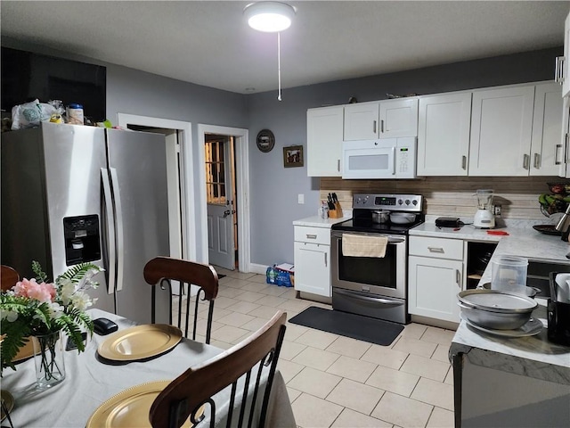 kitchen with white cabinets, decorative backsplash, stainless steel appliances, and light tile patterned floors