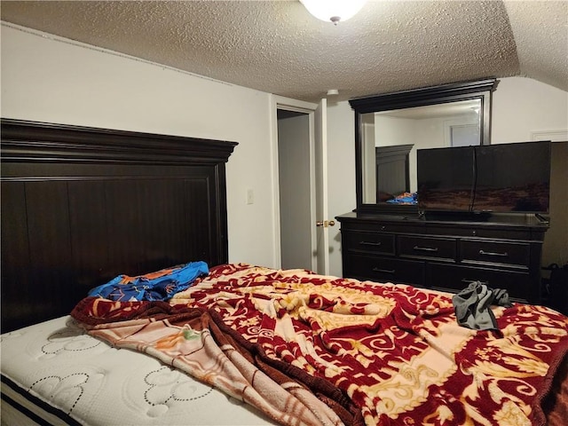 bedroom featuring a textured ceiling and lofted ceiling