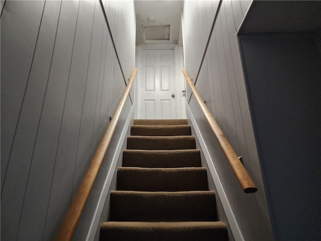 staircase with wood walls