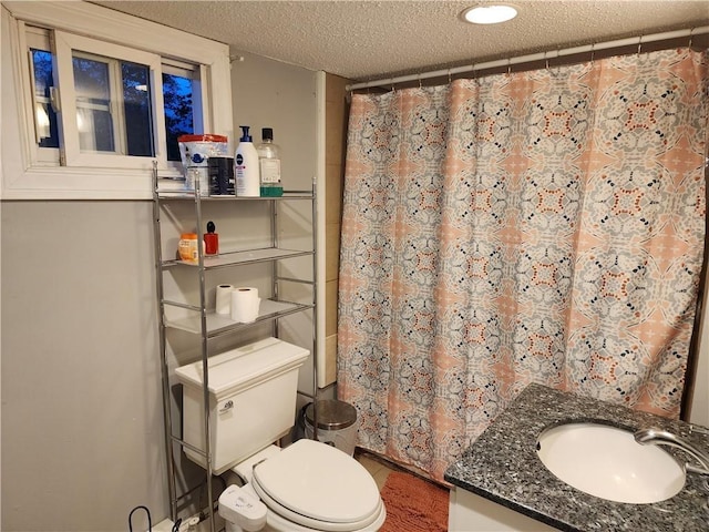 bathroom featuring vanity, a textured ceiling, and toilet