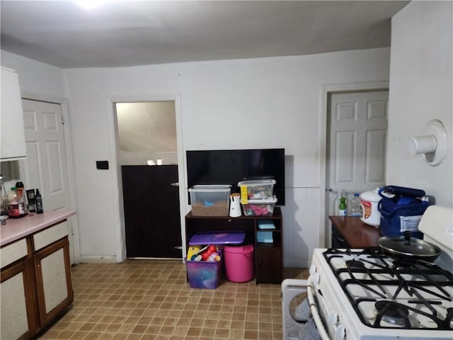 kitchen with white range with gas cooktop and white cabinets