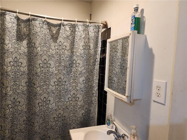 bathroom featuring a shower with shower curtain and sink