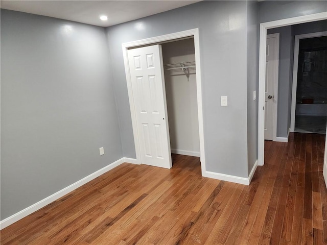 unfurnished bedroom featuring dark hardwood / wood-style floors and a closet